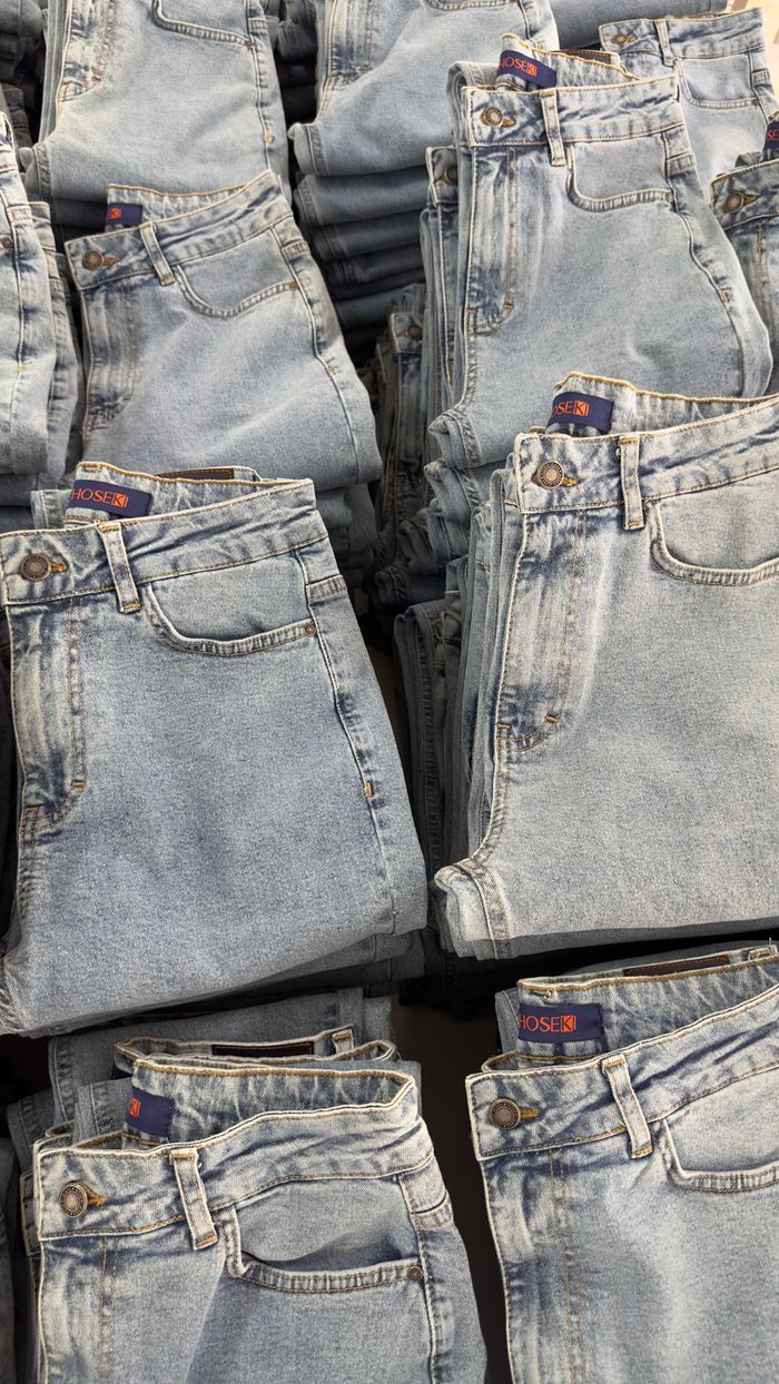 Close-up of folded blue jeans stacked neatly on a retail display.