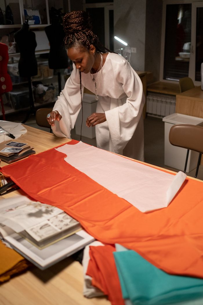 A female designer focuses on fabric design work in a creative studio environment.